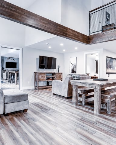 Bright open-plan living room with wood beams and gray sofa